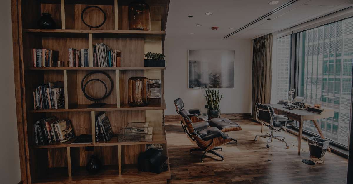 Modern office with a wooden bookshelf and lounge chair, ideal for bookshelf speakers due to its compact space and versatile placement options.