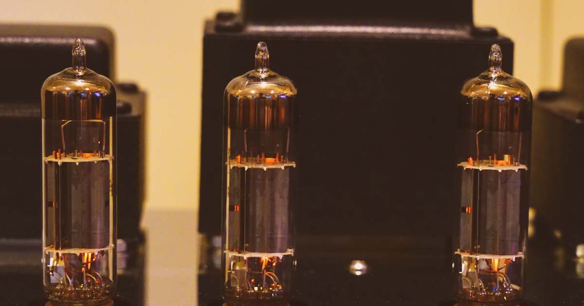 Close-up of three vacuum tubes used in valve amplifiers, showcasing their glowing design and appeal to audiophiles seeking warm, natural sound.